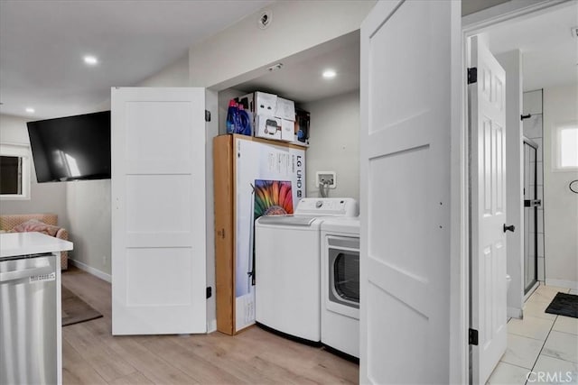 washroom with independent washer and dryer and light hardwood / wood-style floors