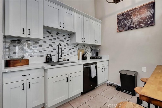 kitchen featuring white cabinets, tasteful backsplash, sink, light tile patterned floors, and dishwasher