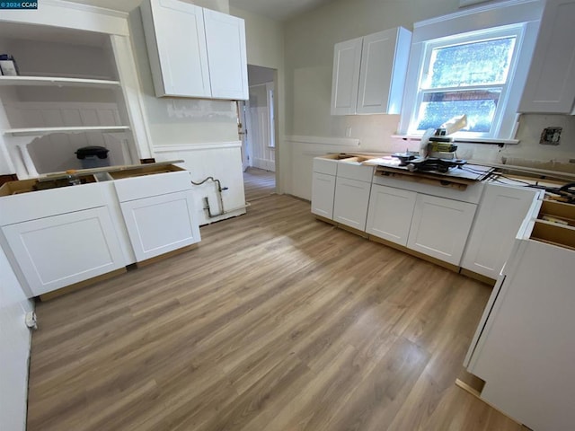 kitchen featuring wood counters, light wood-type flooring, and white cabinetry