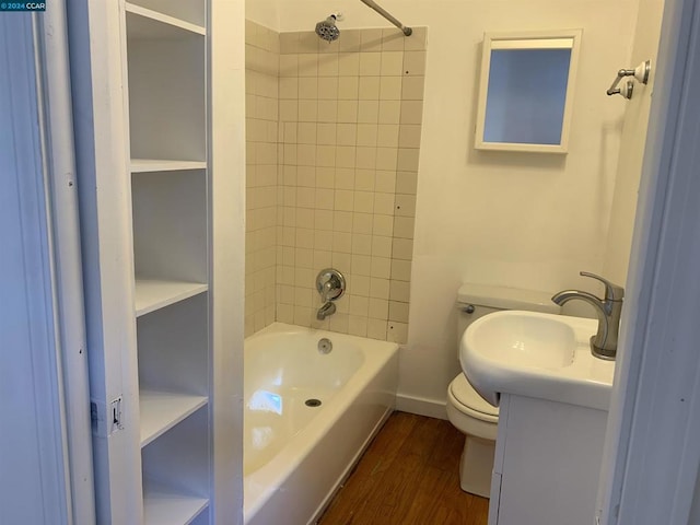 full bathroom featuring hardwood / wood-style floors, vanity, toilet, and tiled shower / bath combo