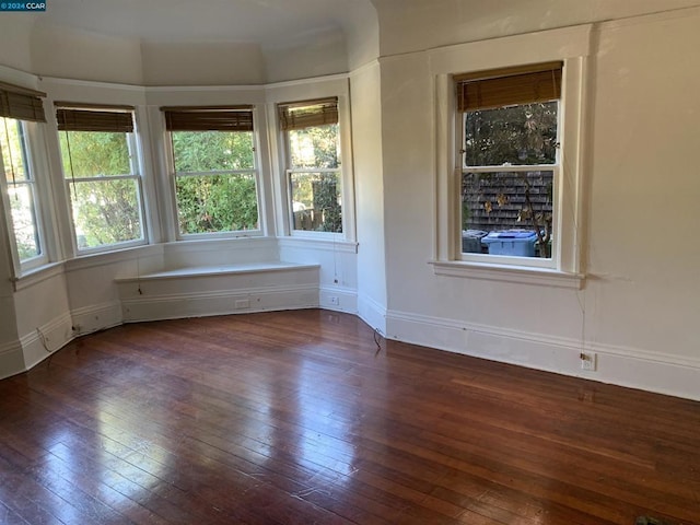 empty room with dark hardwood / wood-style flooring