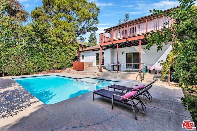 view of swimming pool with an in ground hot tub, a patio area, and a wooden deck