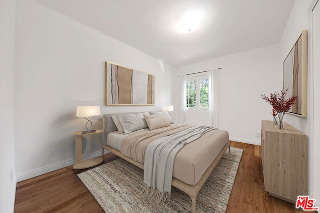 bedroom with dark hardwood / wood-style floors