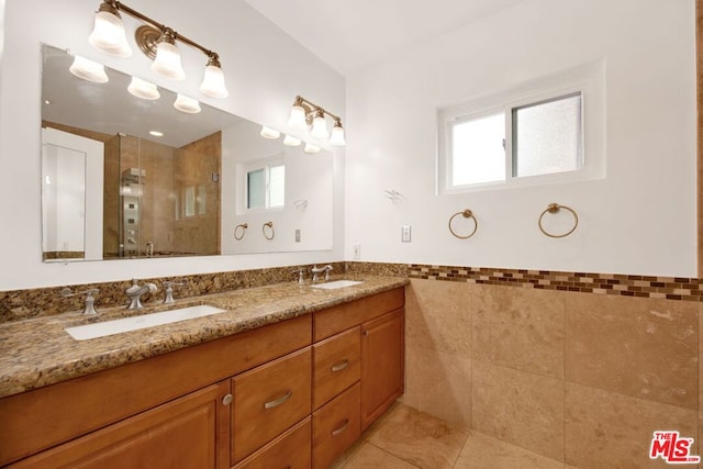 bathroom featuring vanity, tile patterned flooring, a shower with shower door, and tile walls