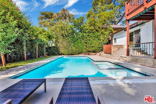 view of pool with an in ground hot tub