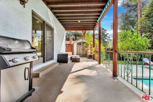 view of patio / terrace with a storage unit, a fenced in pool, and area for grilling