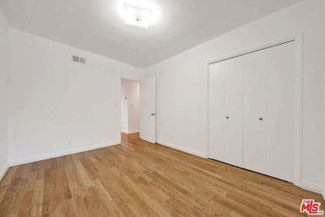 unfurnished bedroom with light hardwood / wood-style floors and a closet