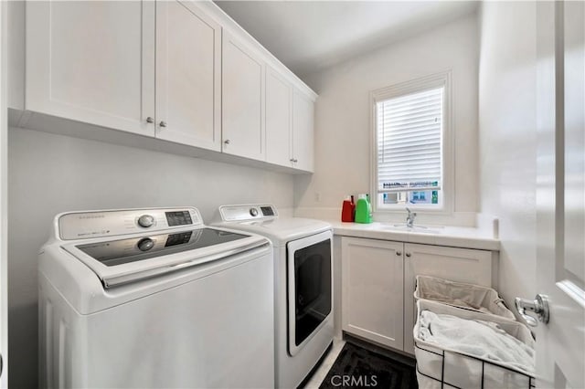 clothes washing area featuring separate washer and dryer, sink, and cabinets