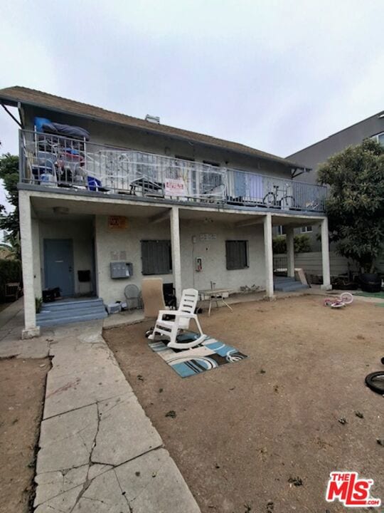 rear view of property with a patio and a balcony