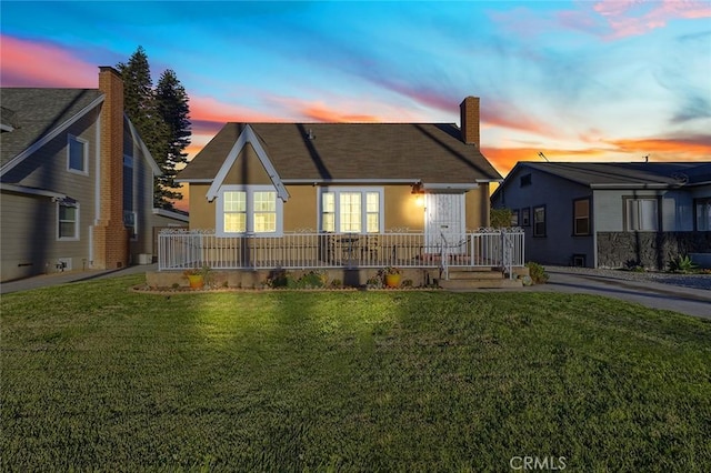 view of front of house featuring covered porch and a lawn