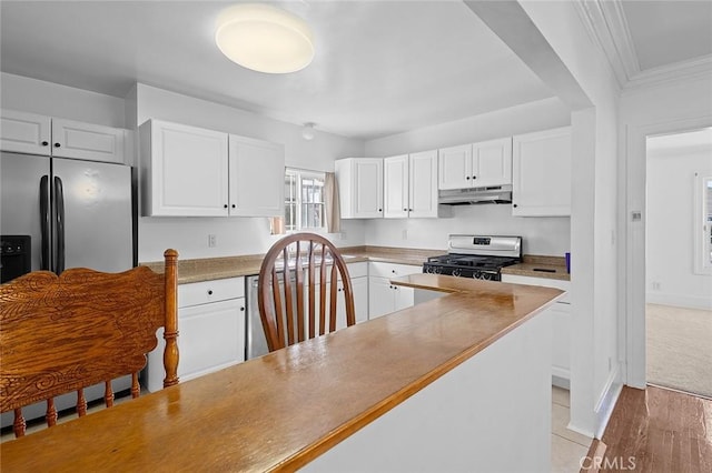 kitchen featuring white cabinets, crown molding, range with gas stovetop, and stainless steel fridge with ice dispenser