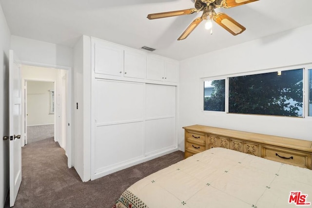 carpeted bedroom featuring ceiling fan and a closet