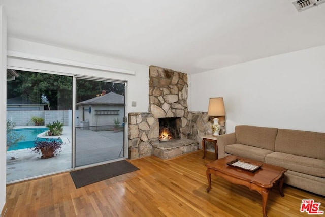 living room with wood-type flooring and a fireplace