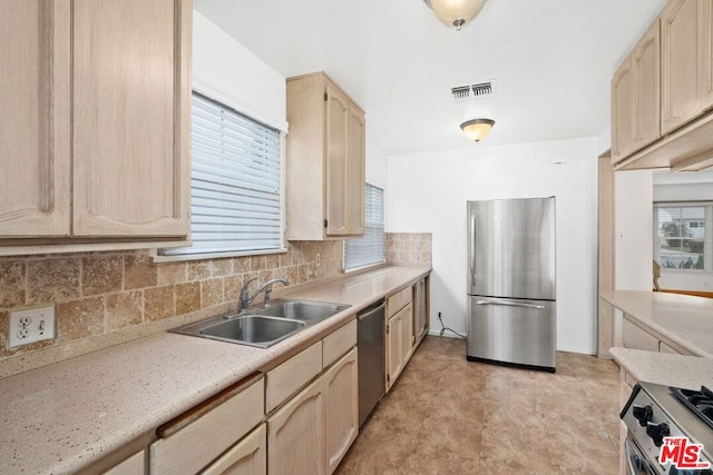 kitchen with light brown cabinetry, decorative backsplash, sink, and appliances with stainless steel finishes