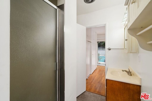 bathroom with vanity, wood-type flooring, and walk in shower