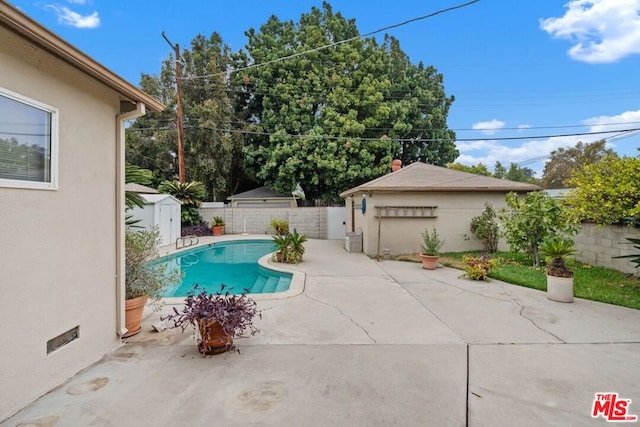 view of pool featuring a patio area and a storage shed