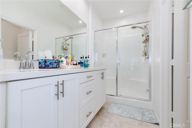 bathroom featuring tile patterned flooring, vanity, and a shower with door