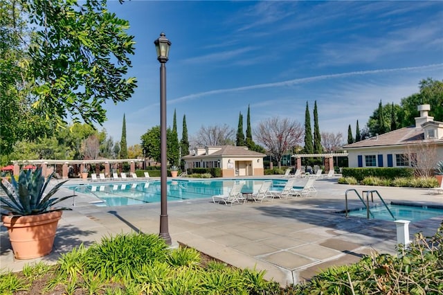 view of swimming pool with an outbuilding and a patio