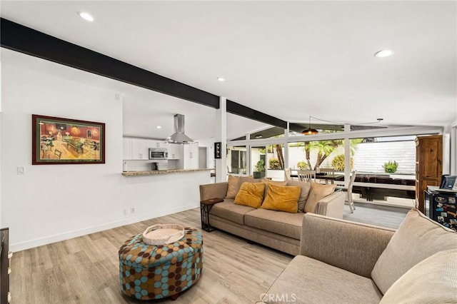 living room featuring vaulted ceiling with beams and light hardwood / wood-style floors