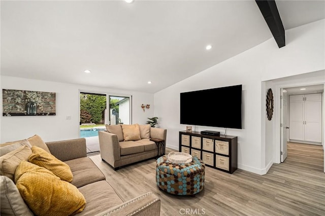 living room featuring light wood-type flooring and lofted ceiling with beams