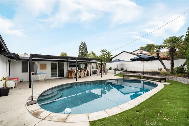 view of swimming pool featuring a yard and a patio