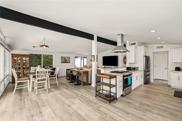 kitchen featuring vaulted ceiling with beams, white cabinetry, wall chimney exhaust hood, and stainless steel appliances