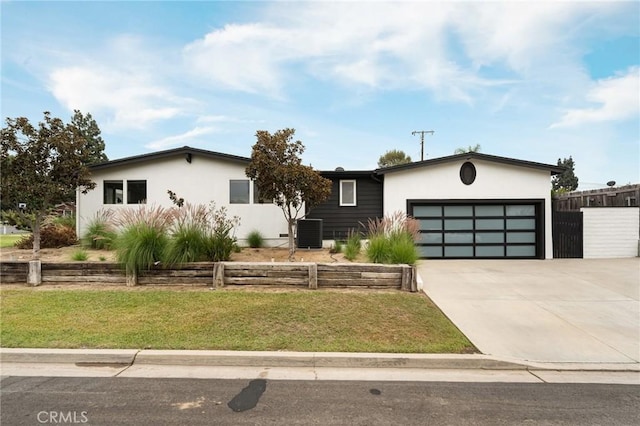 view of front of property with cooling unit, a garage, and a front lawn