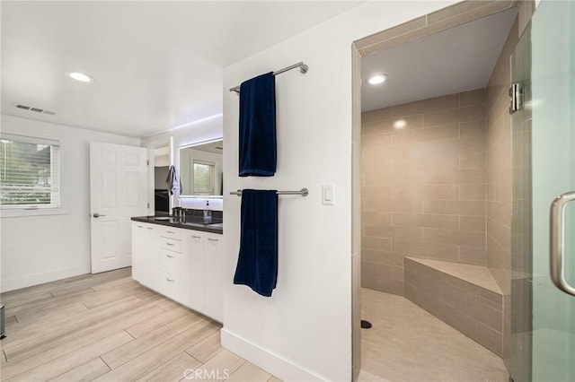 bathroom with plenty of natural light, vanity, hardwood / wood-style floors, and walk in shower