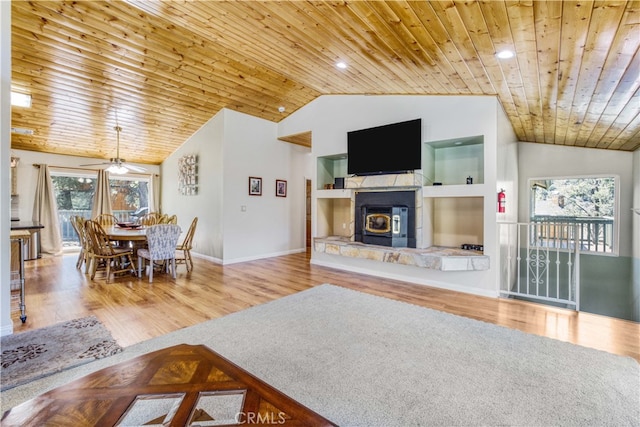 living room with hardwood / wood-style floors, wood ceiling, a wood stove, and plenty of natural light