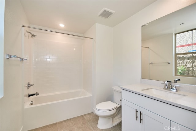 full bathroom featuring tile patterned flooring, tiled shower / bath, vanity, and toilet