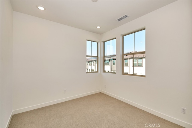 unfurnished room featuring light carpet