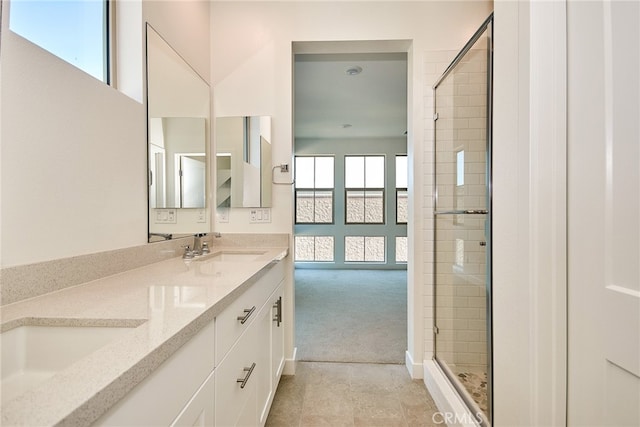 bathroom with a shower with door and vanity