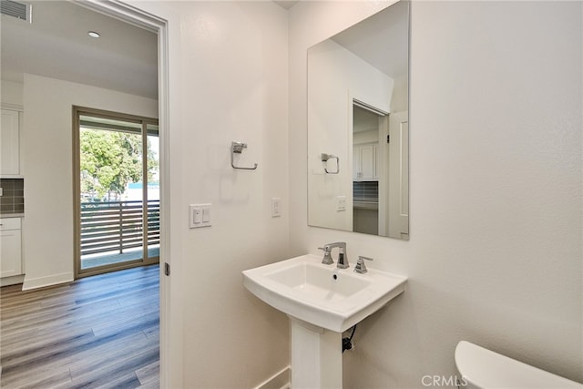 bathroom with tasteful backsplash, hardwood / wood-style floors, and toilet