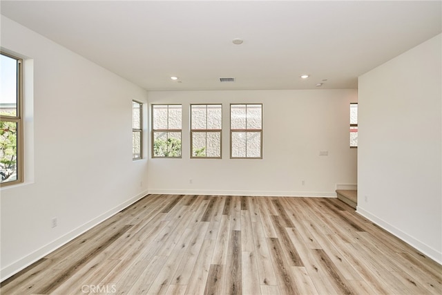 empty room featuring plenty of natural light and light hardwood / wood-style floors