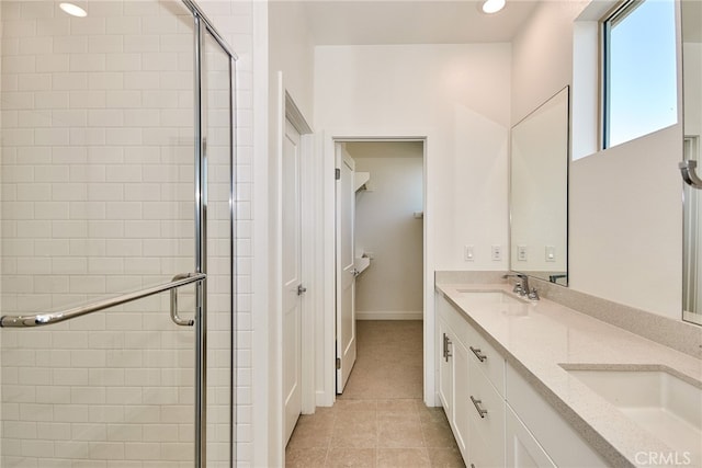 bathroom featuring tile patterned flooring, walk in shower, and vanity