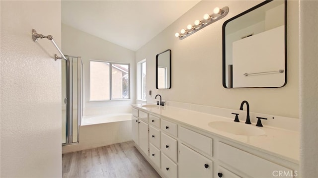 full bathroom with a shower stall, wood finished floors, a sink, and lofted ceiling