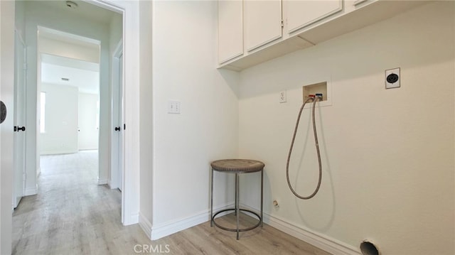 washroom with cabinets, washer hookup, and light hardwood / wood-style flooring