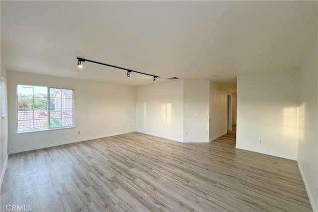 unfurnished room with light hardwood / wood-style flooring and track lighting