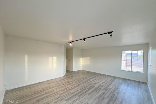 spare room with rail lighting and light hardwood / wood-style flooring