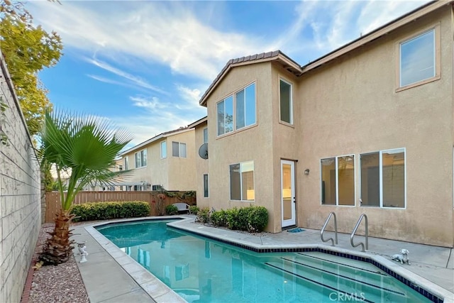 rear view of house featuring a fenced in pool