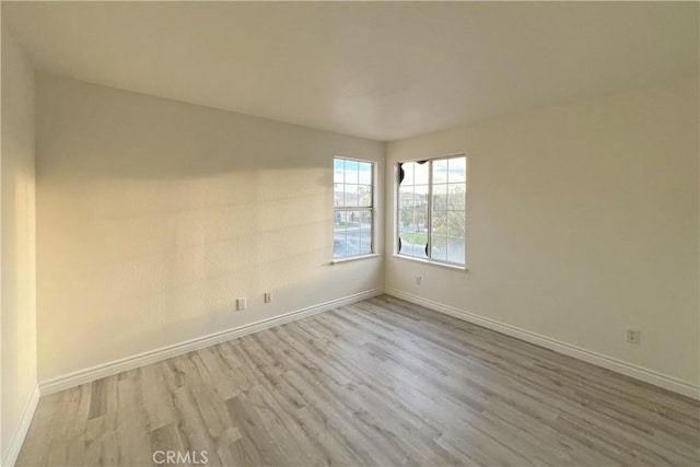unfurnished room featuring baseboards and wood finished floors