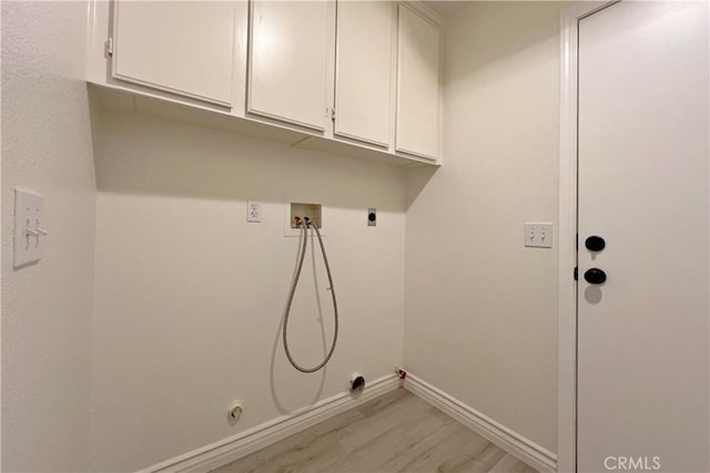 laundry area featuring cabinet space, light wood-style flooring, baseboards, gas dryer hookup, and washer hookup