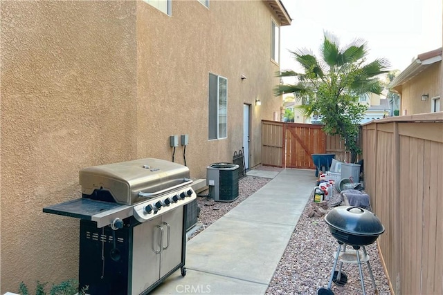 view of patio / terrace with central AC unit, grilling area, fence, and a gate