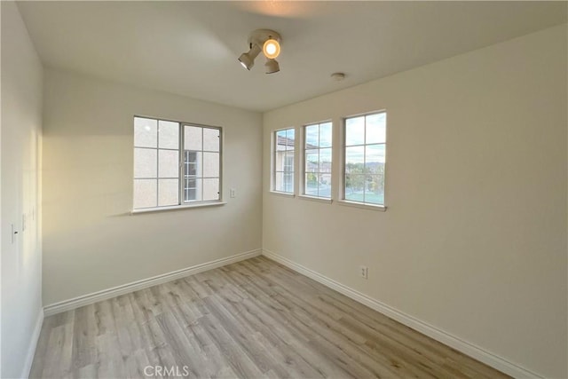 empty room featuring light hardwood / wood-style floors and plenty of natural light