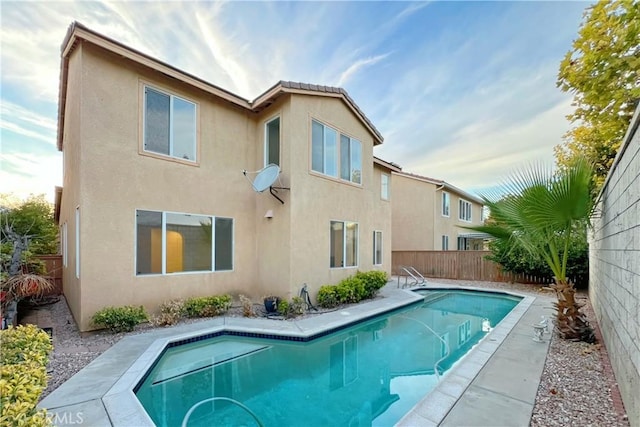 back of house with a fenced in pool