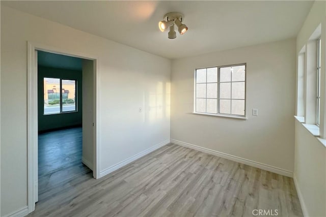 empty room featuring light wood-style floors and baseboards