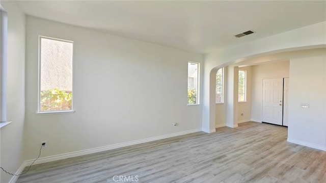 unfurnished room with light wood-type flooring and a wealth of natural light