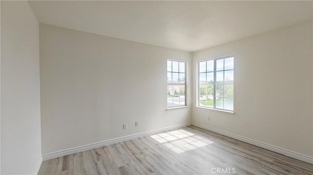 unfurnished room with wood finished floors and baseboards