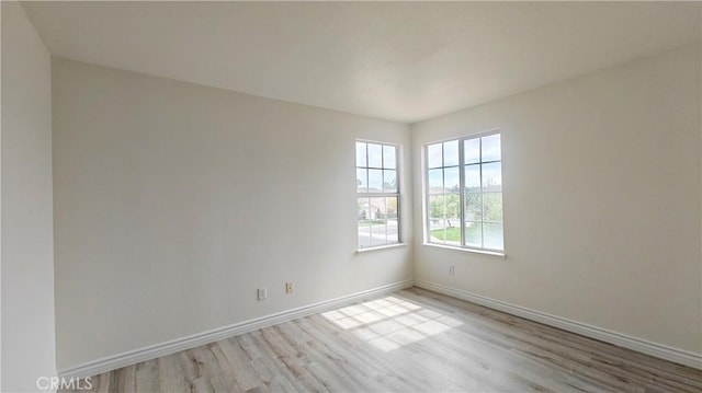 empty room featuring baseboards and wood finished floors