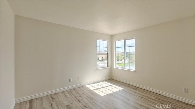 spare room with wood finished floors and baseboards